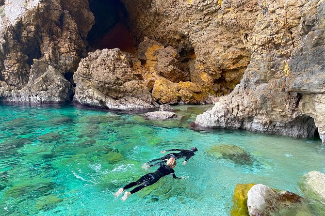 Kayak Paradise: Cala Portixol Snorkel, Cave & Cliff Jumping Tour - Looking up at the 100-meter Cap Negre headland